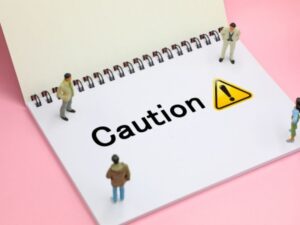 ノートの上のミニチュア人形が伝える防水工事の注意点